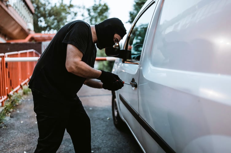 Man with Black Gloves, Balaclava and Screwdriver Trying to Steal a Car. Robbery Concept. Single Use Approved.