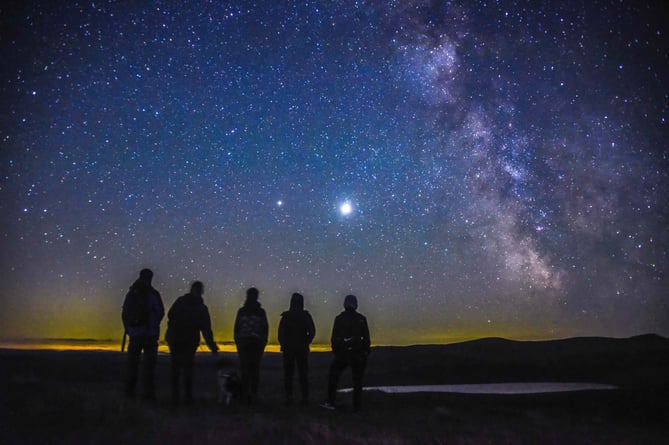 Walkers on a trail at night as part of Visit Wales dark skies trail blazers campaign