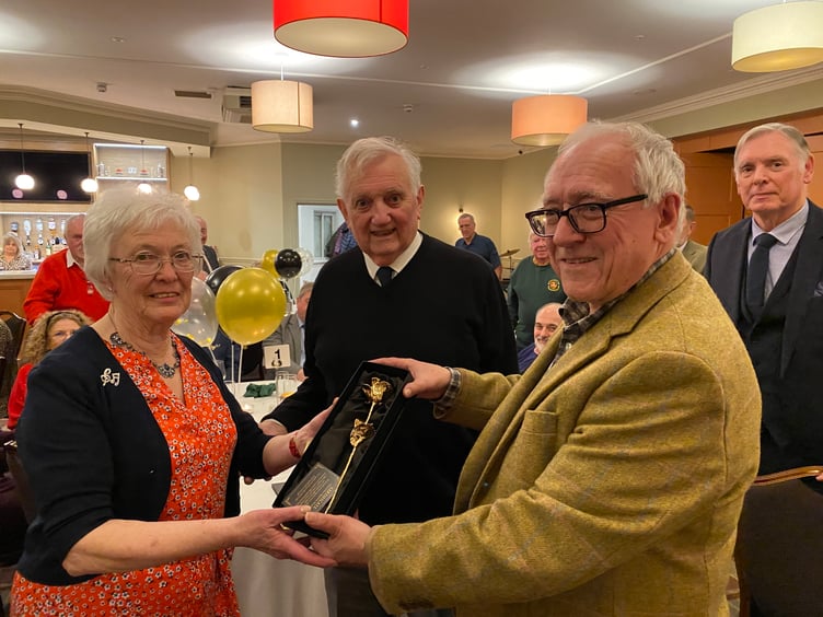 Rosemarie Lewis is presented with a golden rose by Chepstow Male Voice Choir chairman David Benson (right) and watched by her husband Clive.