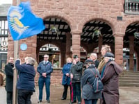 Commonwealth spirits un-dampened by weather during flag raising