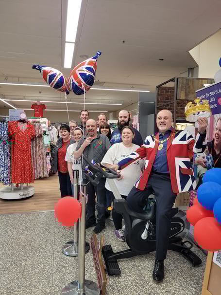 Cllr Ed O'Driscoll on a spin bike in Morrisons, Ross-on-Wye