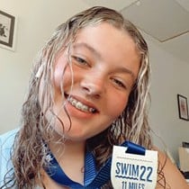 Carys Clarkson holding up her Swim 22 medal