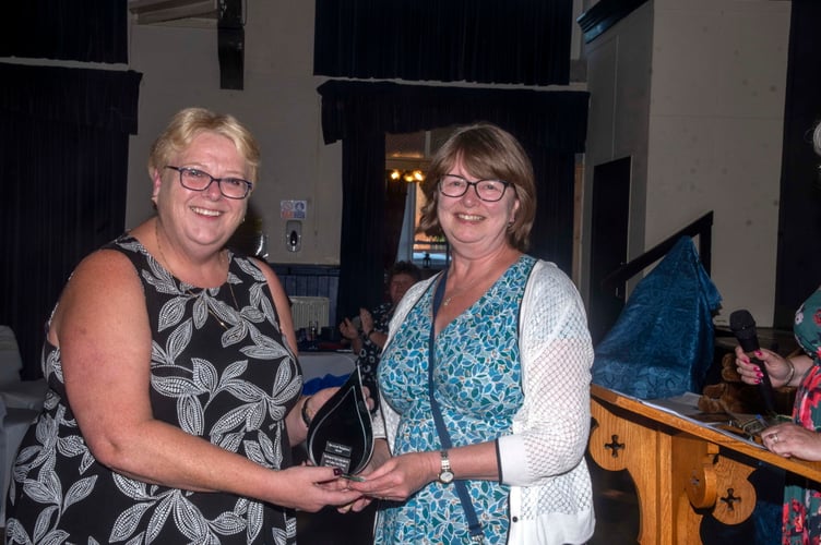 Margaret Lucas won the Good Neighboiur award. Her daughter received it on her behalf from Review sales executive Carole Richards