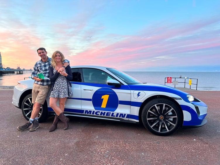 Vanessa Ruck and husband posing next to a racing car