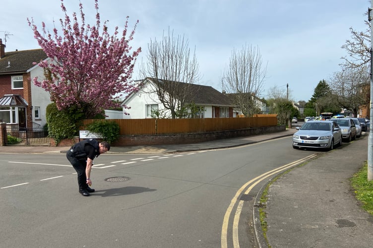 A police officer marks up evidence on the road surface