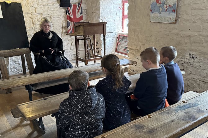 Four ‘history ambassador’ pupils meeting ‘Catherine Drew’ played by historical re-enactor Mary Dutson at Dean Heritage Centre
