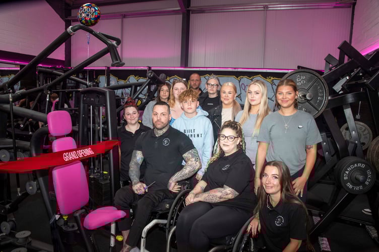 Gareth Hughes and Carrianne Halford with staff and supporters in the gym.
