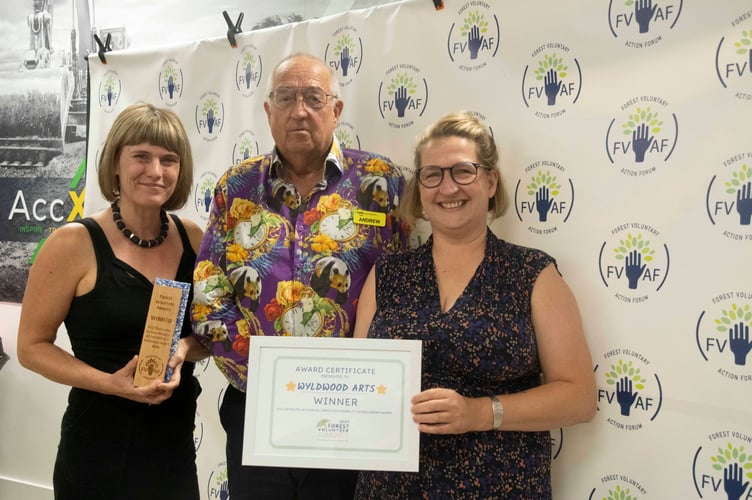 Sarah Wyatt of Wyldwood Arts and Lucy Ellis-Howell receive the accessibility  and inclusion award from Andy Morgan-Watts of the Forest Dementia Action Alliance.