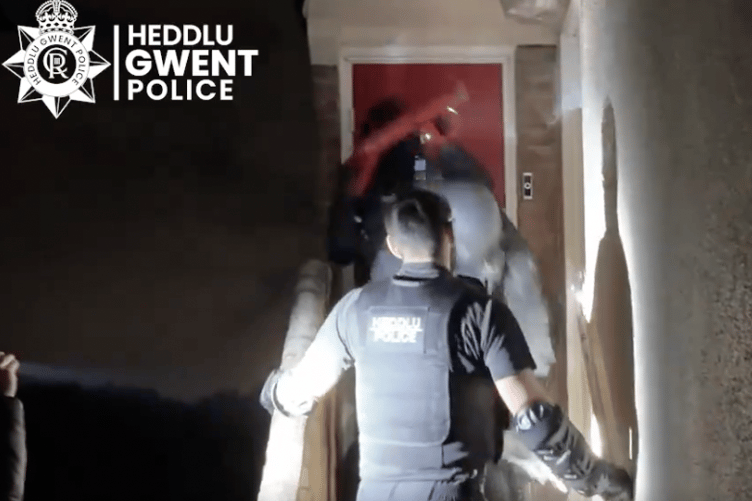 Police break down a door in the early morning raids