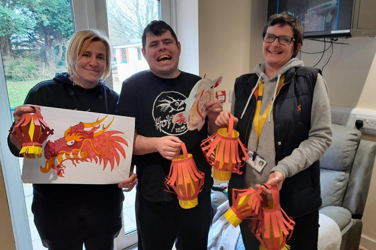 Photo caption: Service user Rhys and his support workers with the artwork created to celebrate Chinese New Year.