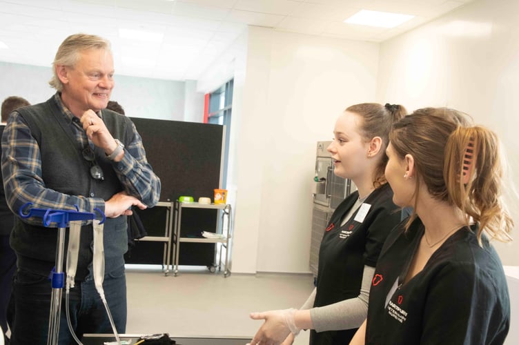 Martin Clunes talking to studebts Carmen Christians and Keira Parsons.