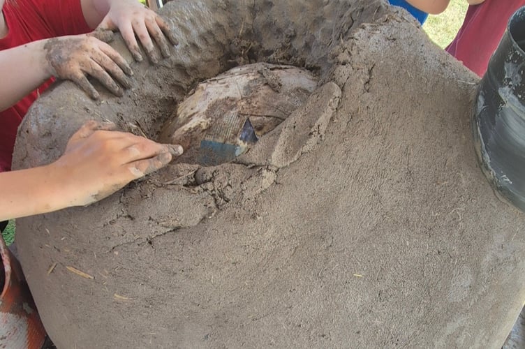 Pupils get hands on making the oven.