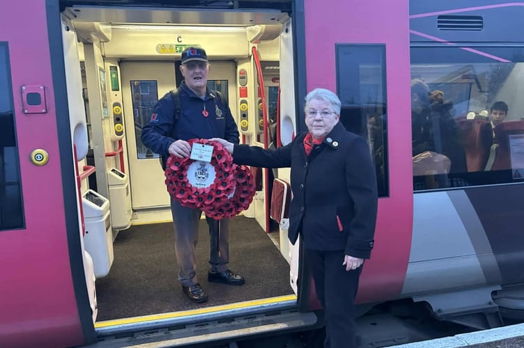 Lydney town councillor Carol Harris hands Mel Rudge  the wreaths for Poppies to Paddington at Lydney station.