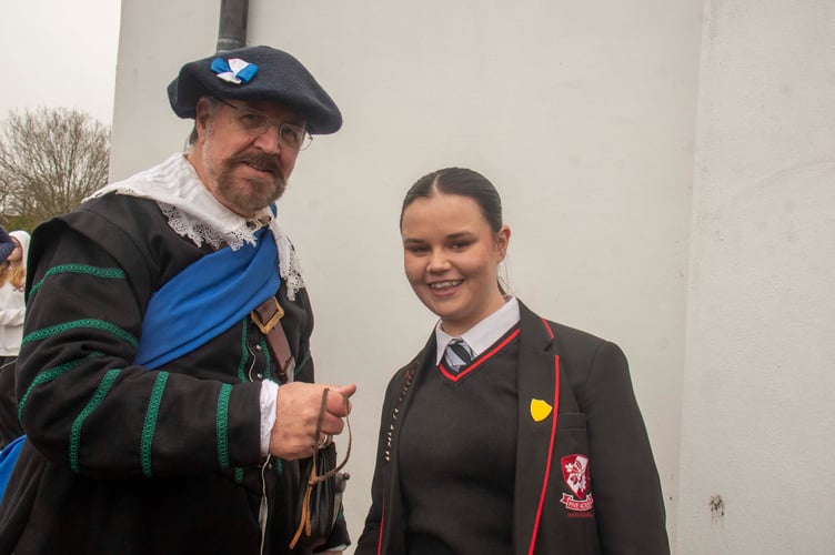 Five Acres High student Lillie Wildin is presented with a purse of coins by Ian Blyth for reading a poem about the battle.