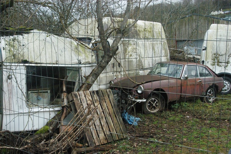 Scrap vehicles, including a 1960s MGB GT, vans and a caravan remain in situ and are still visible at Doward Farm.