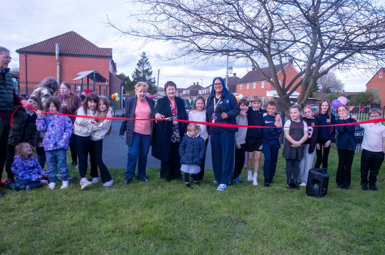 Parish councillors Audrey Tullett, Jan Stead and Justine Burgess cut the ribbon at the new-look play area watched by local children.