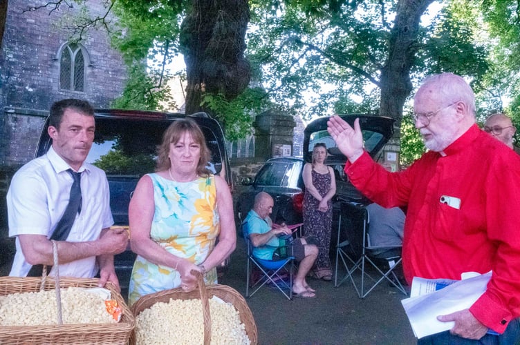 Rev David Rees blesses the bread and cheese held by Wilf and Margaret Slaughter.