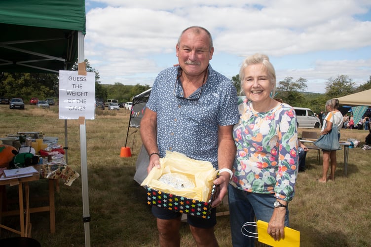 Steve Lewis tries to guess the weight of the fruit cake baked by Sara Rickard.