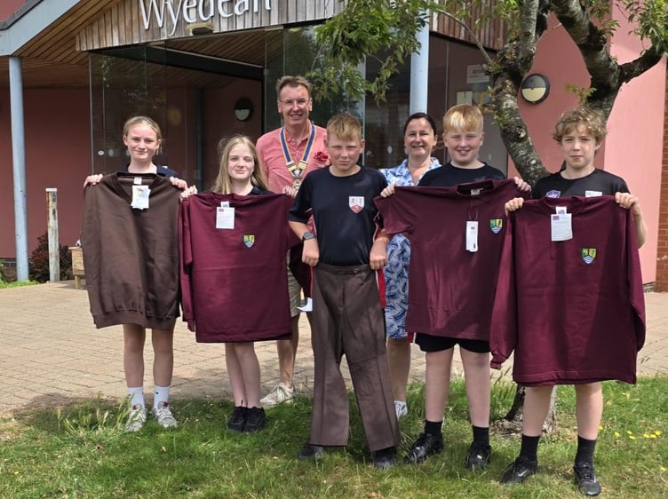 Guy Wilson of Chepstow Rotary and Wyedean School's Principal Gwennan Jeremiah with pupils and some of the uniforms that were sent to Ukraine.